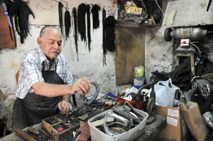 Impression encadrée : Shoemaker. Un cordonnier dans son atelier de réparation des chaussures