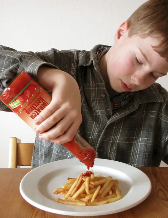 Impression encadrée : L'enfant mange des chips. Impression encadrée : L'enfant mange des chips.