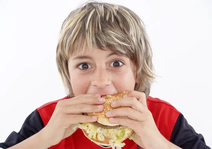 Impression encadrée : L'enfant mange un hamburger.