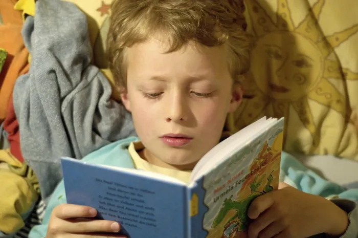 Impression encadrée : L'enfant lisant dans son lit. Impression encadrée : L'enfant lisant dans son lit.