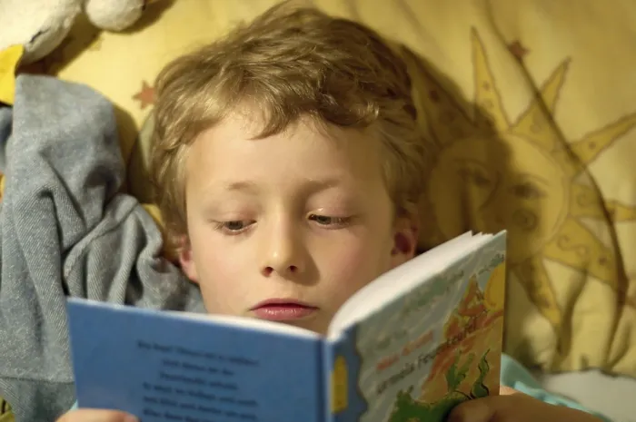 Impression encadrée : L'enfant lisant dans son lit.