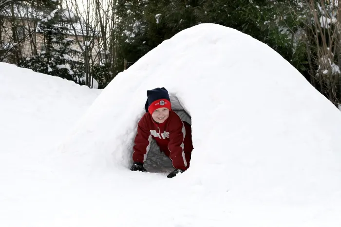 Impression encadrée : L'enfant joue dans l'igloo. Impression encadrée : L'enfant joue dans l'igloo.
