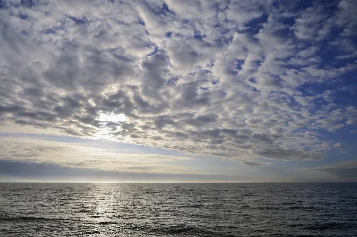 Impression encadrée : Ciel couvert, formations nuageuses devant le soleil couchant.