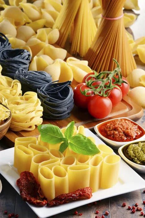 Impression encadrée : Composition avec différents types de pâtes sur table de cuisine. Impression encadrée : Composition avec différents types de pâtes sur table de cuisine.