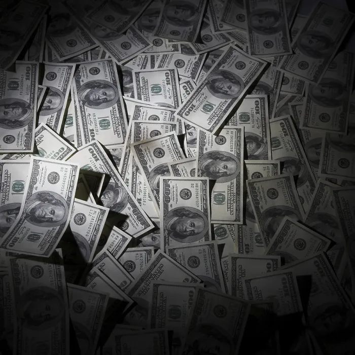 Impression encadrée : Cent dollars empilés en arrière-plan.