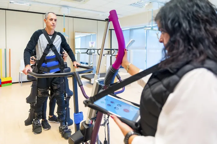 Impression encadrée : Exosquelette mécanique. Assistante médicale de kinésithérapie féminine avec une personne handicapée soulevée par un squelette robotique. Impression encadrée : Exosquelette mécanique. Assistante médicale de kinésithérapie féminine avec une personne handicapée soulevée par un squelette robotique.