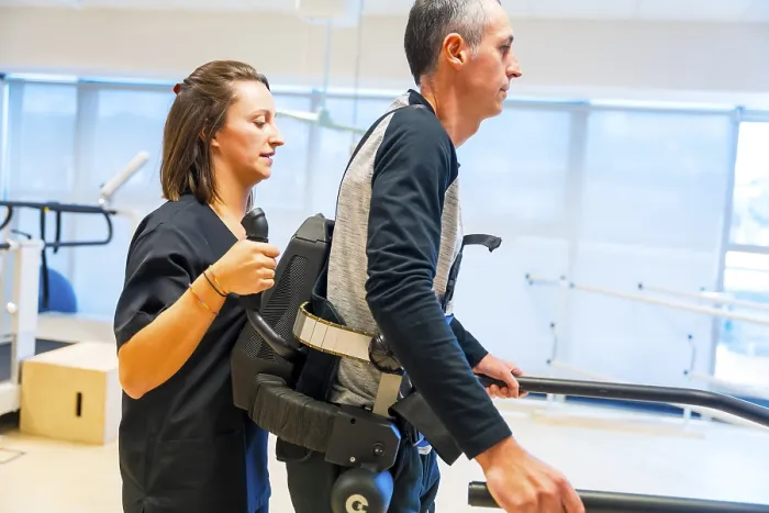 Impression encadrée : Exosquelette mécanique. Assistante médicale de kinésithérapie féminine aidant une personne handicapée avec un squelette robotique pour marcher. Impression encadrée : Exosquelette mécanique. Assistante médicale de kinésithérapie féminine aidant une personne handicapée avec un squelette robotique pour marcher.