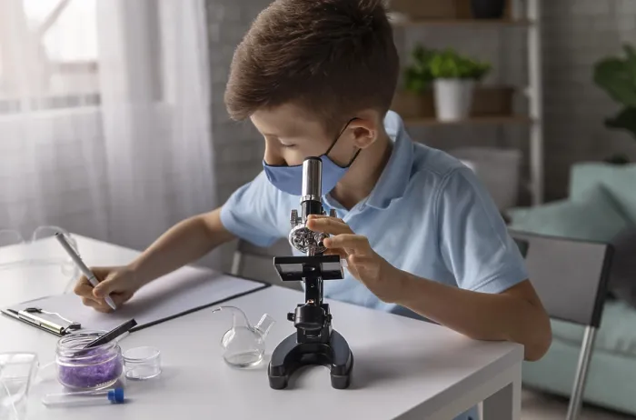 Impression encadrée : Plan large enfant apprenant avec microscope.