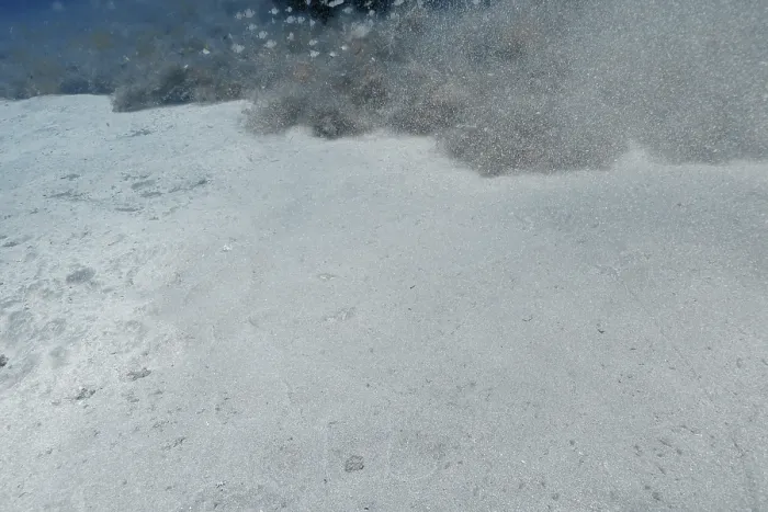 Impression encadrée : Sable et particules flottent dans l'eau.