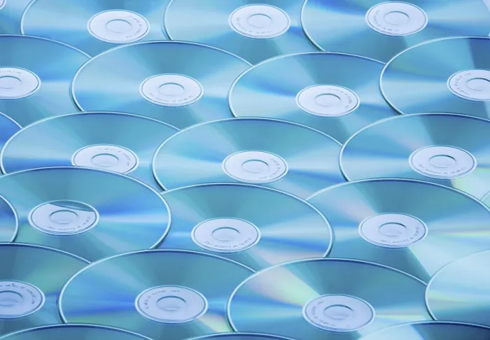 Impression encadrée : Une table pleine de CD-ROMs et de DVDs.