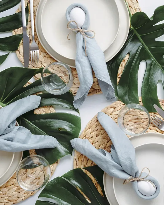 Impression encadrée : Table de Pâques tropicale. Vue du haut de la mise en table pour Pâques chrétienne avec des œufs de lapin décorés de feuilles de monstera.