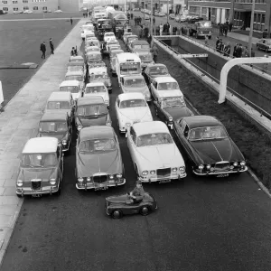 Print of a 1967 photograph showing Patrick Edwards in the smallest BMC car