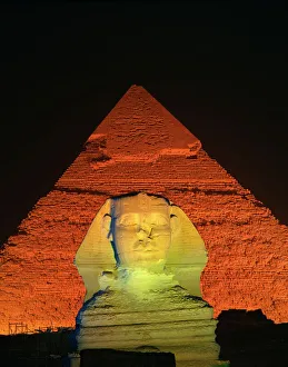 Egyptian Archaeological Sites Impressions: The Sphinx and one of the pyramids illuminated at night, Giza, UNESCO World Heritage Site