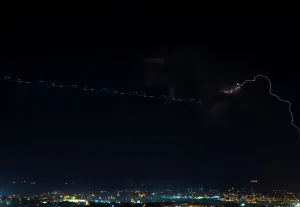 Un chemin laissé par un avion est vu près dune tempête éclairée, vue de Mdina