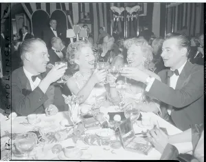 Anne Baxter Partageant un Toast avec des Colleagues.