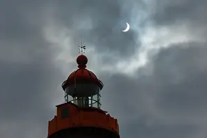 Brittany Coast Scenery Impressions: Solar eclipse in a cloudy sky above the lighthouse at Pointe Saint-Mathieu