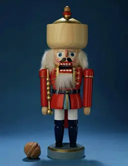 Christmas Celebration Decorations Impressions: Close-up of a nutcracker with a walnut beside it