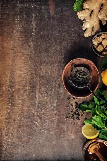 Herbal Tea Ingredients Impressions: Tea composition on rustic background: tea, mint, lemon, ginger. Flat lay top view