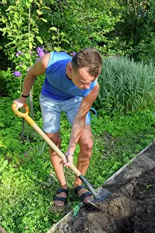Young Gardener Impressions: A young man digging a flower bed on the plot A young man digging a flower bed on the plot