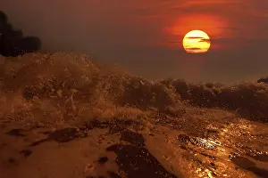 Atmospheric Ocean View Impressions: Big wave front with bubbles and splashes at sunset