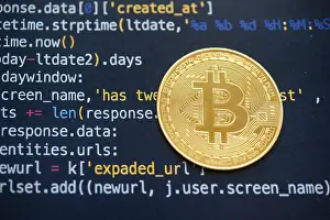 Virtual Money Transfer System Impressions: A Bitcoin coin on top of computer programming code