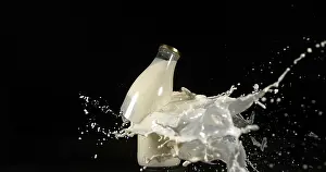 Dark Colored Background Image Impressions: Bottle of Milk Exploding against Black Background