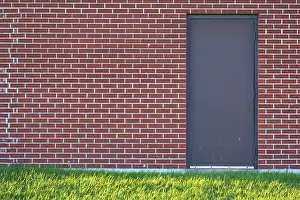 Ontario Canada Landscape Photography Impressions: Brick wall with rectangular door and a meadow in front of it