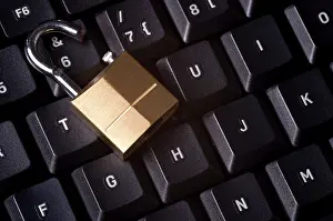 Computer Hacking Prevention Impressions: A broken padlock on top a computer keyboard to represent the concept of computer security breach