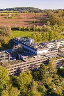 Renewable Energy Power Generation Impressions: Building complex with solar panels surrounded by fields