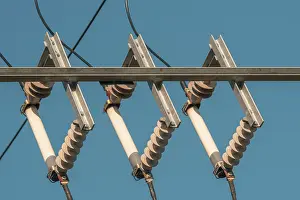 Power Industry Equipment Impressions: Ceramic eletric insulators outside on the sky background