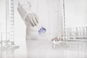 Chemist At Work Impressions: Chemist checking liquid in flask in a lab