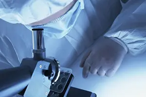 Chemist In Lab Coat Impressions: Chemist looking through a microscope