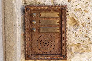 Traditional Building Design Impressions: Close up of an old rusty intercom embedded in weathered stone wall