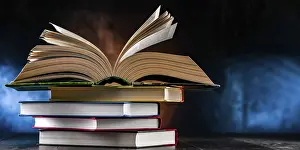 Open Book Impressions: A composition with an open book lying on a stack of other books