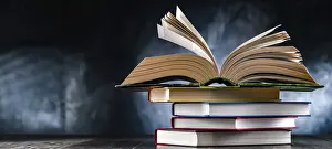 Open Book Impressions: A composition with an open book lying on a stack of other books