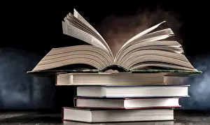 Open Book Impressions: A composition with an open book lying on a stack of other books