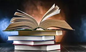 Book Stack Impressions: A composition with an open book lying on a stack of other books