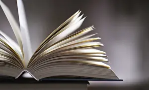 Literature Study Space Impressions: A composition with an open book lying on a stack of other books