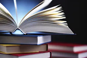 Piled Up Books Impressions: A composition with an open book lying on a stack of other books