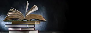 Open Book Impressions: A composition with an open book lying on a stack of other books