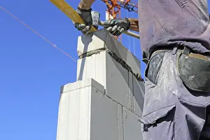 Residential Building Construction Impressions: Construction worker (bricklayer) on the building site