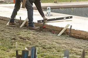 Building Inspection Impressions: Construction worker checking level on wet deck cement