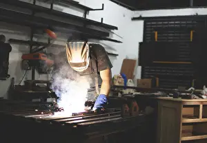 Factory Interior Photography Impressions: Deaf man using a welding torch in the workshop