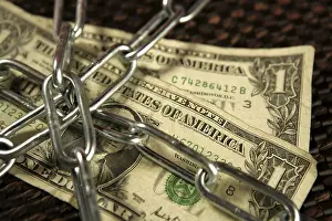 Brown Background Studio Shot Impressions: One Dollar notes in chains studio shot over brown background