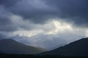 Dramatic Mountain Landscape Impressions: Dramatic mountain landscape under cloudy sky with rays of light