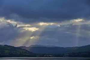 Scottish Lake Photography Impressions: Dramatic rays of light through a cloudy landscape over a lake
