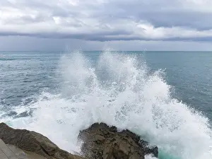 Panoramic Ocean View Impressions: A dramatic scene as powerful waves collide with rugged rocks under a brooding sky