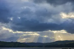 Dramatic Mountain Landscape Impressions: Dramatic sky with rays of light breaking through the clouds over a mountainous landscape