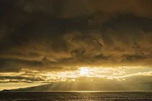 Soft Lightning In The Evening Sky Impressions: Dramatic sunset with sun rays breaking through the clouds over the sea