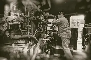 Deserted Railway Station Impressions: Engine driver working on steam train engine